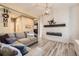 Inviting living room featuring a cozy sectional sofa, electric fireplace, and wood-look flooring at 26072 E Fremont Pl, Aurora, CO 80016