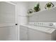 Efficient laundry room equipped with modern washer and dryer, plus storage shelves and closet at 7651 E 26Th Ave, Denver, CO 80238