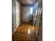 Hallway with wood-look floors leading to a white front door and adjacent rooms at 5129 Chandler Way, Denver, CO 80239