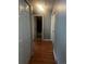 Hallway with wood flooring leading to a full bathroom, and with closet and doorway on each side at 5129 Chandler Way, Denver, CO 80239