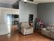 Living room with hardwood floors, reclining chairs, and a glimpse of the fireplace at 5129 Chandler Way, Denver, CO 80239
