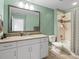Full bathroom with neutral green color, bathtub shower, and vanity with white cabinets at 16406 W 85Th Ln # A, Arvada, CO 80007