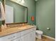 Clean half bathroom with earthy green wall and white cabinets at 16406 W 85Th Ln # A, Arvada, CO 80007