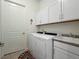 Bright laundry room with white cabinets, washer, dryer, and utility sink at 16406 W 85Th Ln # A, Arvada, CO 80007