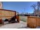 Backyard patio area with privacy fence and green space beyond at 2870 Jasmine St, Denver, CO 80207