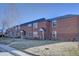 Full view of brick townhomes each with a front yard and an inviting entrance at 2870 Jasmine St, Denver, CO 80207