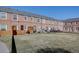 Backyard view of brick townhomes with private patios and green space at 2870 Jasmine St, Denver, CO 80207
