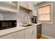 Well-lit kitchen features stainless steel sink, modern appliances, and white cabinets at 2870 Jasmine St, Denver, CO 80207