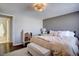 Bright main bedroom featuring ensuite bathroom, hardwood floor, neutral colors, and decorative lighting at 2870 Jasmine St, Denver, CO 80207