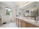 Bathroom featuring a double vanity, large mirror, tile floors and a glass door shower at 604 S Yarrow St, Lakewood, CO 80226