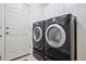Laundry room with stacked, black washer and dryer, and a white door at 604 S Yarrow St, Lakewood, CO 80226