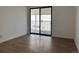 Bright bedroom with a sliding glass door leading to the balcony, natural light, and hardwood floors at 943 S Zeno Way # 205, Aurora, CO 80017