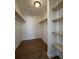Spacious walk-in closet featuring hardwood flooring and built-in shelving at 943 S Zeno Way # 205, Aurora, CO 80017