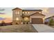 Beautiful two-story home with a manicured lawn, a two-car garage, and solar panels on the roof at sunset at 3234 Picketwire Way, Castle Rock, CO 80108