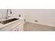 Modern laundry room featuring a stainless steel sink, quartz countertop, tiled floor, and white cabinets at 366 Agoseris Way, Castle Rock, CO 80104