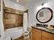 Bathroom with bathtub, decorative stone detail, vanity with granite countertop, and round mirror at 383 S Franklin St, Denver, CO 80209