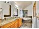 Bright bathroom featuring dual sinks, a soaking tub, and elegant slate tile flooring at 383 S Franklin St, Denver, CO 80209
