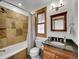Stylish bathroom features marble tile, wooden window trim, granite countertop, and modern vanity lighting at 383 S Franklin St, Denver, CO 80209