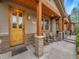 Inviting front porch with wood columns, stone accents, rocking chairs and stained wood ceiling at 383 S Franklin St, Denver, CO 80209