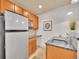 Kitchenette featuring stainless refrigerator, granite counters, and wooden cabinetry at 383 S Franklin St, Denver, CO 80209