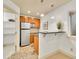 Kitchenette featuring stainless refrigerator, granite counters, and wooden cabinetry at 383 S Franklin St, Denver, CO 80209