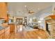 Open-concept living room with a stone fireplace, hardwood floors, a ceiling fan, and a kitchen island at 383 S Franklin St, Denver, CO 80209