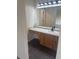 Bathroom vanity with light wood cabinets, matte black hardware, and large mirror at 6240 Everett Ct # D, Arvada, CO 80004