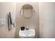 Compact bathroom featuring a round mirror and a classic pedestal sink at 6240 Everett Ct # D, Arvada, CO 80004