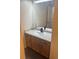 Bathroom vanity with light wood cabinets, matte black hardware, and laminate counters at 6240 Everett Ct # D, Arvada, CO 80004