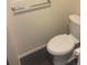 Modern toilet with a chrome towel bar and tiled flooring at 6240 Everett Ct # D, Arvada, CO 80004