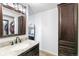 Bathroom featuring granite counters, dark wood cabinets, vanity mirror and a walk-in closet at 7193 S Newport Way, Centennial, CO 80112