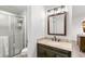 Well-lit bathroom with a granite countertop, dark wood vanity, and glass-enclosed shower at 7193 S Newport Way, Centennial, CO 80112