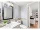 Neutral half-bathroom features a framed mirror, updated vanity, tile accents, and an adjacent office at 7193 S Newport Way, Centennial, CO 80112