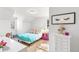 Bright bedroom featuring wood floors, a bed with colorful bedding, and an accent table at 7193 S Newport Way, Centennial, CO 80112