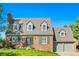 Lovely two-story brick home featuring dormer windows, a manicured lawn, and an attached garage at 7193 S Newport Way, Centennial, CO 80112
