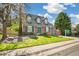 A well-maintained two-story brick house with a neat lawn, mature trees, and a two-car garage at 7193 S Newport Way, Centennial, CO 80112