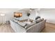 Spacious living room featuring an oversized gray sofa, stylish decor, and a flat screen TV at 7193 S Newport Way, Centennial, CO 80112