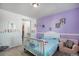 Purple-walled bedroom with crib and adjoining bathroom at 13267 E 108Th Ave, Commerce City, CO 80022