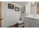 Bathroom with a toilet, sink with vanity and framed landscape pictures at 4555 E 121St Ct, Thornton, CO 80241