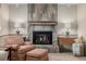 Cozy fireplace with stone surround and mantle, complemented by armchairs and lighting at 4555 E 121St Ct, Thornton, CO 80241