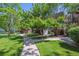 Well-maintained backyard with lush grass, mature trees, and a charming walkway at 7250 Eastmoor Dr # 122, Denver, CO 80237