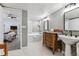 Large bathroom features double sinks, a tub, vintage dresser, and bright lighting at 7250 Eastmoor Dr # 122, Denver, CO 80237