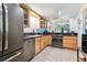 Clean kitchen with stainless steel appliances, tile flooring, and wood cabinets at 7250 Eastmoor Dr # 122, Denver, CO 80237