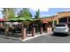 View of restaurant patio area showing covered seating, a brick enclosure and nearby parking at 7250 Eastmoor Dr # 122, Denver, CO 80237