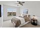 Bright bedroom with a ceiling fan and large window overlooking the trees and distant landscape at 9019 E Panorama Cir # D320, Englewood, CO 80112