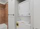 Laundry area with stacked washer and dryer unit, complete with tiled shower at 9019 E Panorama Cir # D320, Englewood, CO 80112