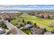 Aerial view of houses in a neighborhood by a large grassy field near a lake at 2330 Sandpiper Dr, Lafayette, CO 80026