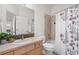 Cozy bathroom featuring a floral shower curtain, tile details, and a wooden vanity at 2330 Sandpiper Dr, Lafayette, CO 80026
