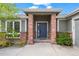 Close-up of a home's front entrance with a blue door, brick pillars, and manicured landscaping at 2330 Sandpiper Dr, Lafayette, CO 80026
