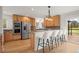 Modern kitchen with stainless steel appliances, wooden cabinetry, and a breakfast bar for seating at 2330 Sandpiper Dr, Lafayette, CO 80026